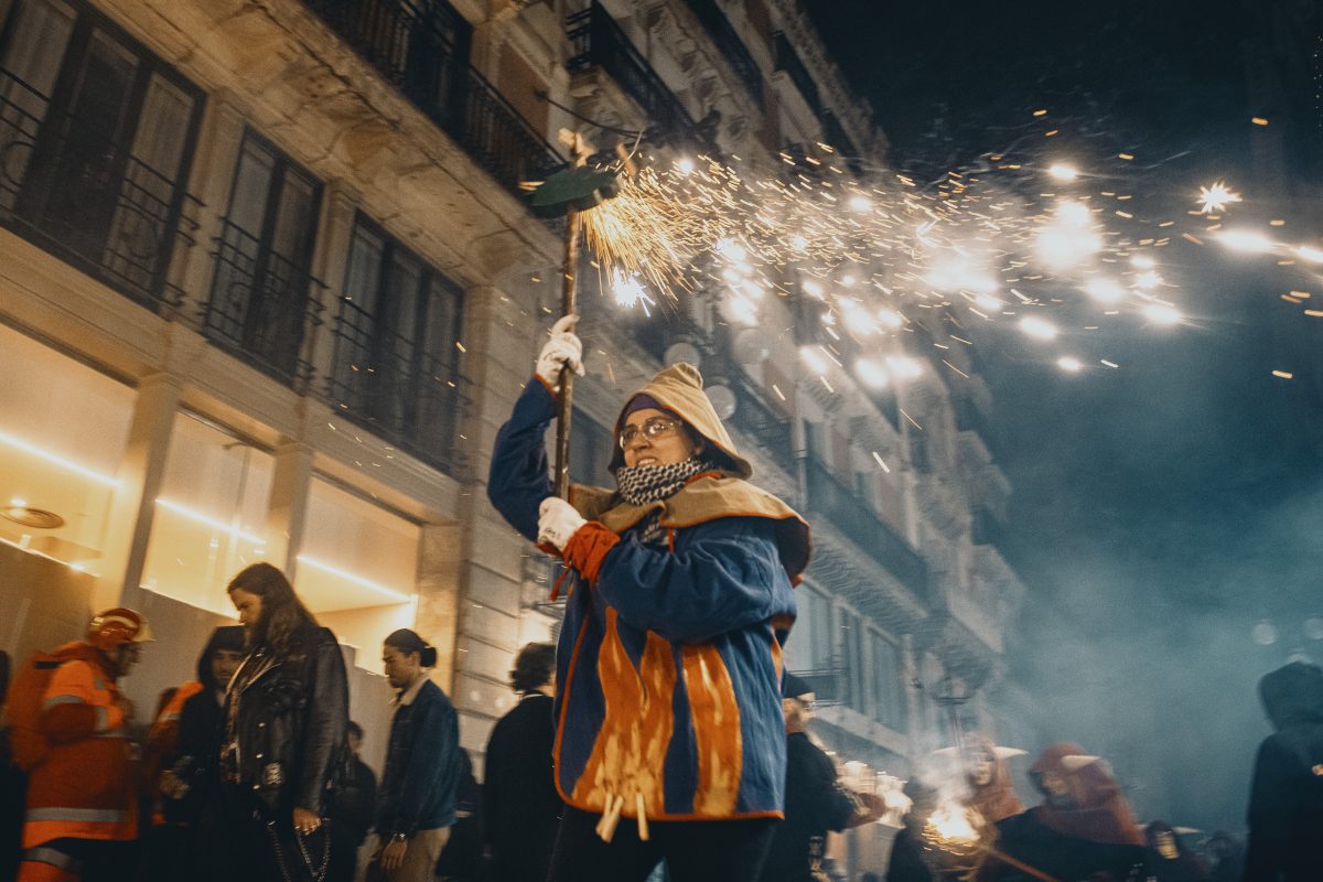 A fire runner in a devil costume dance to traditional drums under fireworks during the 'Correfocs' (fire-runs) at Barcelona's winter city festival 'Santa Eulalia' 2025