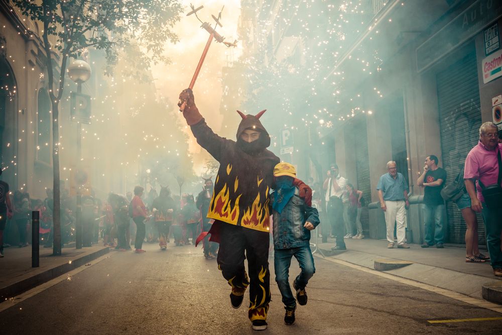 August 21st, 2014. Barcelona, Spain: Children in devil costumes dance to traditional drums under fireworks during the "Correfocs" at the "Festa Major de Gracia".