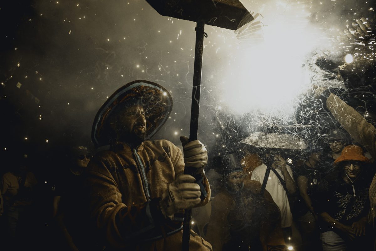 Sitges, Spain. 5 July, 2024: A fire runner dances to traditional drums under sparks during some 'correfocs' in Sitges