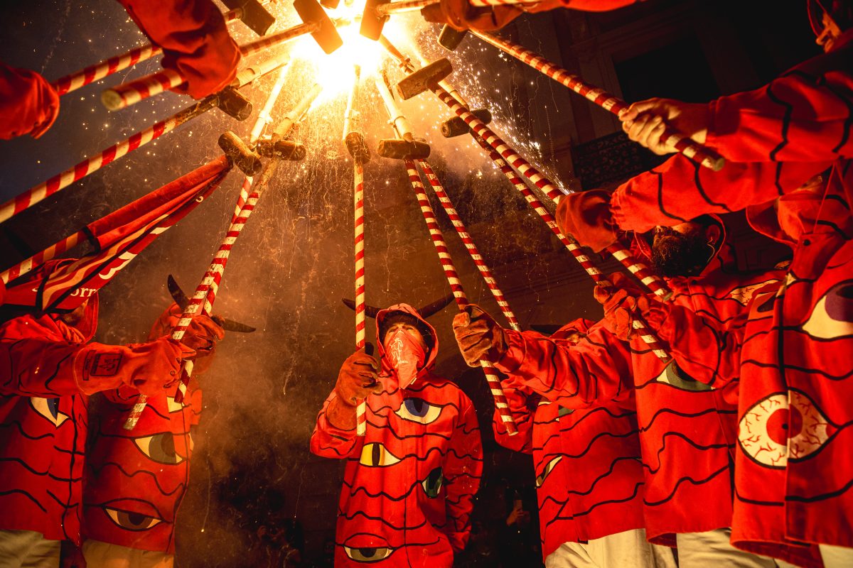 Barcelona, Spain. 25 May, 2024: Fire runners in devil costumes gather to enlighten their stick mounted firecrackers celebrating the 30th anniversary of the 'Diables de les Corts'