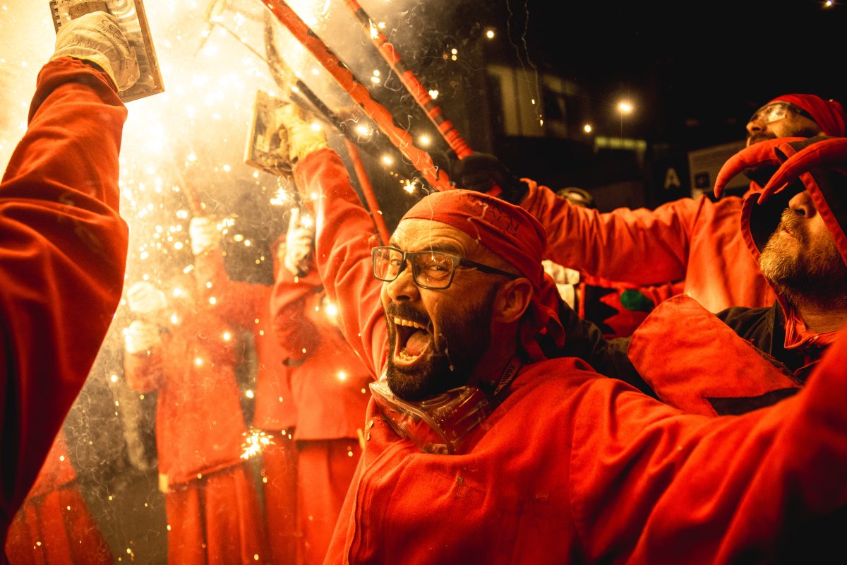Fire runners dance to traditional drums under fireworks during the 'Festa Major de la Sagrada Familia'.