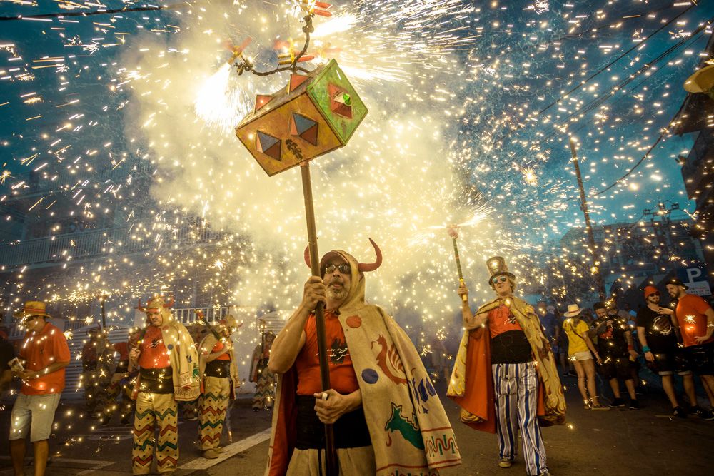 Sitges, Spain. 23 August, 2017: Members of 'Diables de Sitges - colla jove' set off their fireworks among the crowd of spectators at the 'Festa Major de Sitges'.