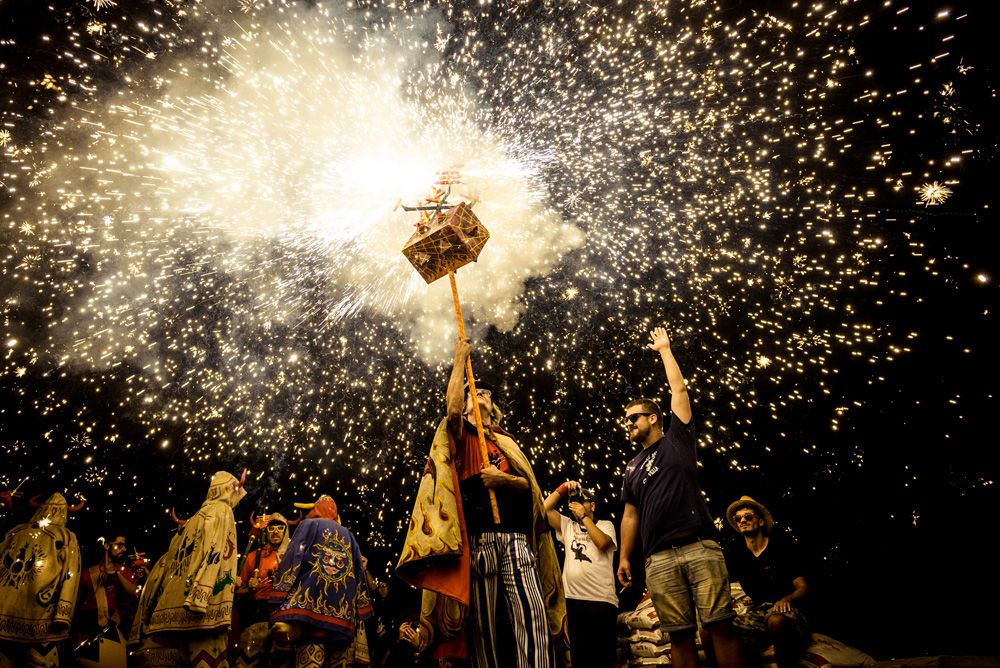 Sitges, Spain. 24 August, 2017: Members of 'Diables de Sitges - colla jove' set off their fireworks among the crowd of spectators at the 'Festa Major de Sitges'.