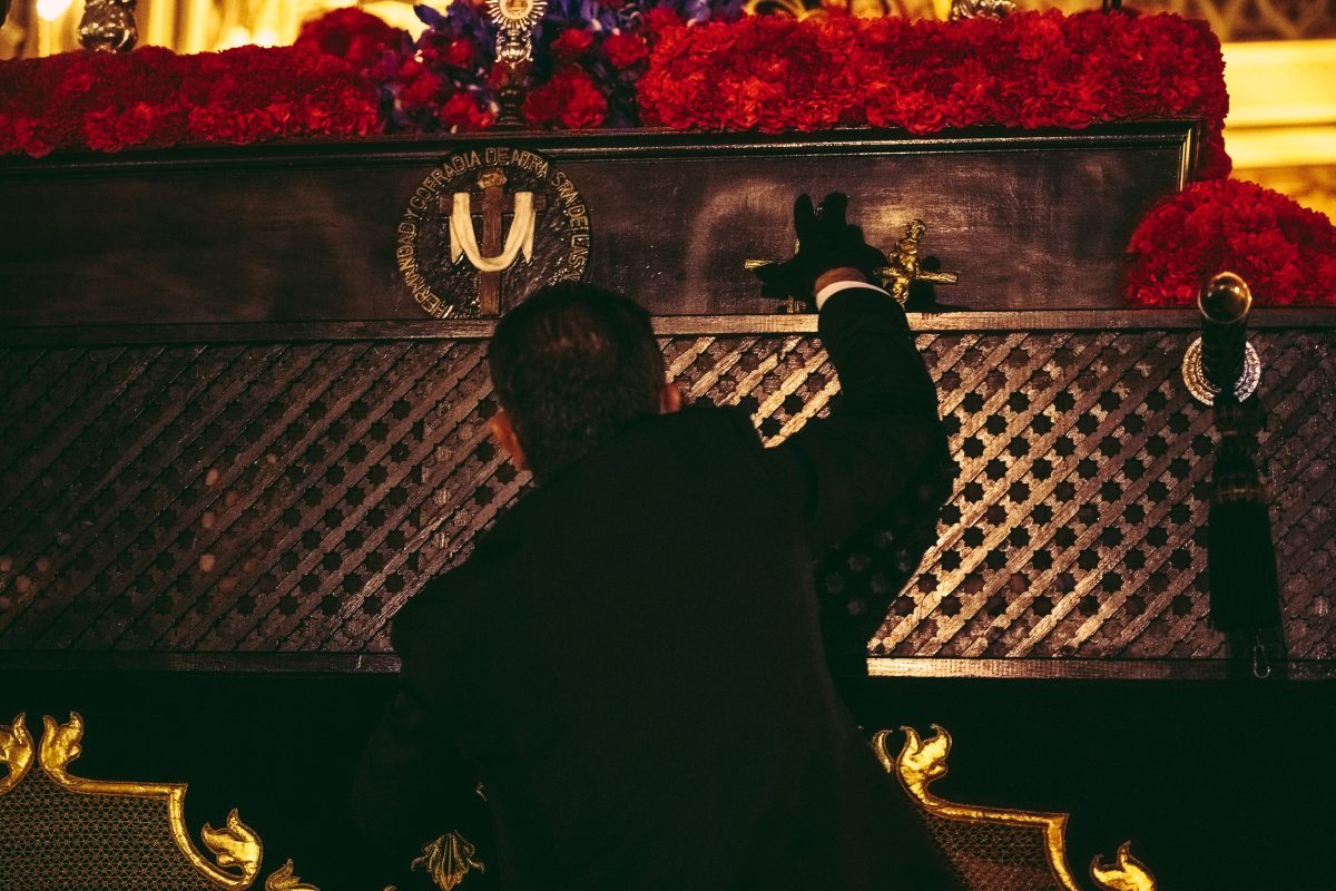 A brother of the 'Nuestra Senora de las Angustias' brotherhood talks to the 'costaleros' (porters) carrying their religious image through Barcelona during the Good Friday procession