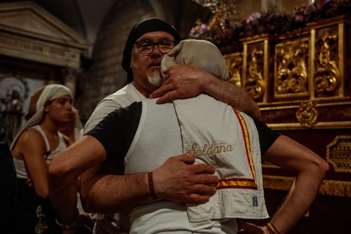 'Costaleros' (porters) of the 'Nuestra Senora de las Angustias' brotherhood react as they reach with their float Barcelona's St Jaume church at the end of the Good Friday procession