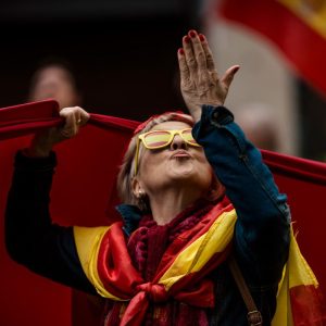 December 6th, 2015. Barcelona, Spain: A demonstrator give kisses to someone on a balcony decorated with an independence flag as she protests for the indissoluble unity of the Spanish nation and against a hypothetical independence of Catalonia on the Spanish constitution day.