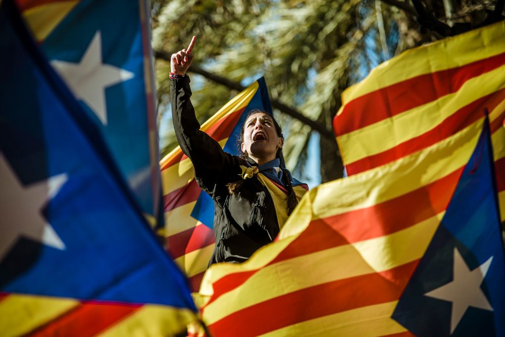 Barcelona, Spain. 6 February, 2017: A young Catalan pro-indepence demonstrator shouting slogans is seen among waving 'estelada' flags in front of the regional High Court during a demonstration in support of Catalan ex-president Artur Mas at the first day of his trial over his role in 2014's symbolic independence referendum