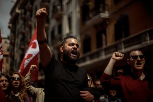 Communists shout slogans as they demonstrate for the working class marching through Barcelona at labor day.