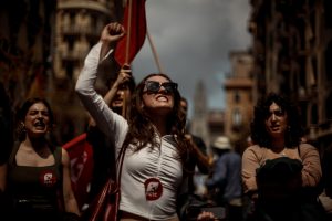 Communists shout slogans as they demonstrate for the working class marching through Barcelona at labor day.