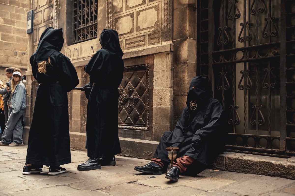 Barcelona, Spain. 13 April, 2025: Hooded penitents from the 'Congregacion del Santisimo Cristo de la Buena Muerte' brotherhood walk the streets of Barcelona's Gothic Quarter during their Palm Sunday procession