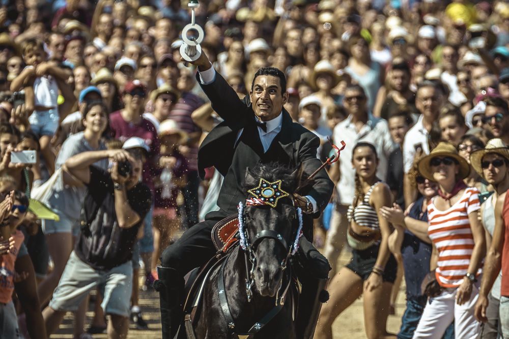 Ciutadella, Spain. 24 June, 2017: Ciutadella De Menorca, Balearic Islands, Spain - A 'caixer' (horse rider) spears a suspended ring with his lance during the training session for the 'Jocs des Pla' (medieval tournament) during the traditional 'Sant Joan' (Saint John) festival in Ciutadella de Menorca
