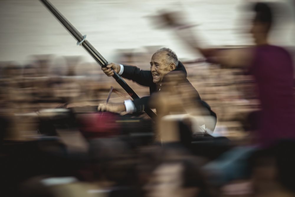 Ciutadella, Spain. 24 June, 2017: A 'caixer' (horse rider) aims his lance at a suspended ring as he gallops through the cheering crowd during the 'Jocs des Pla' (medieval tournament) during the traditional 'Sant Joan' (Saint John) festival in Ciutadella de Menorca