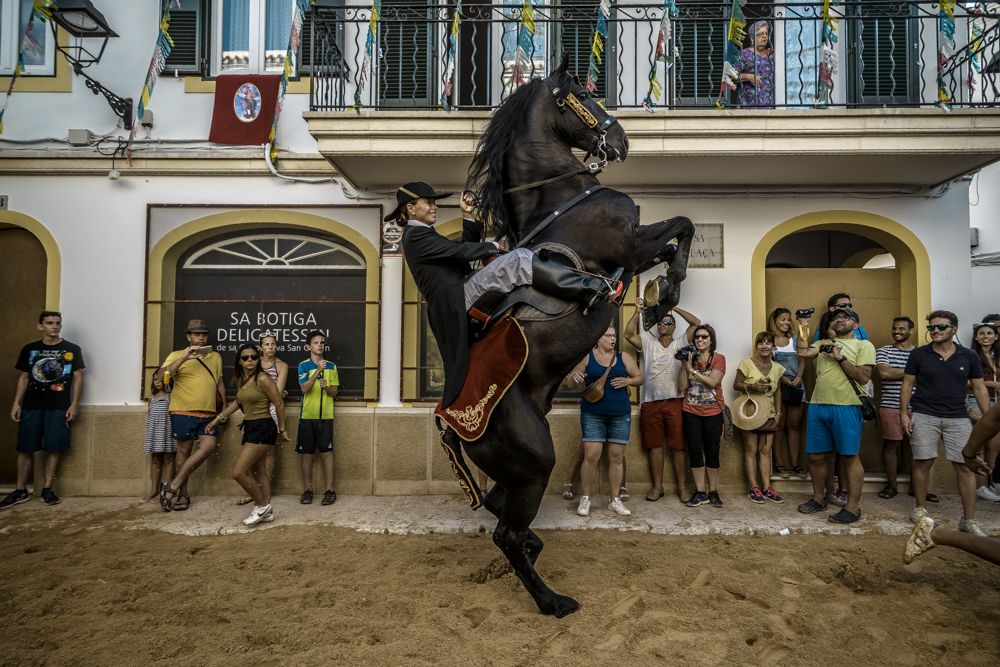 Es Migjorn Gran, Spain. 29 July, 2017: A 'caixer' (horse rider) rears up on his horse in between the cheering crowd during the 'Jaleo' of the traditional 'Sant Cristofol' (Saint Christopher) festival in Es Migjorn Gran, the town's patron saint fiesta