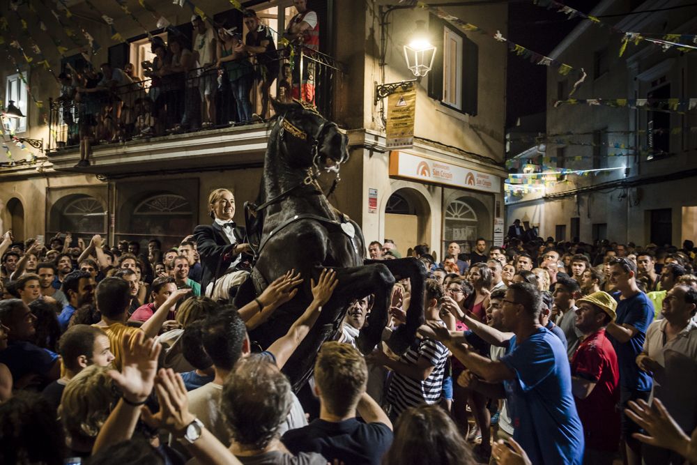 Es Migjorn Gran, Spain. 31 July, 2016: 
A 'caixer' (horse rider) rears up on his horse in front of the public as he rides through the streets at the beginning of the traditional 'Sant Cristofol' (Saint Christopher) festival in Es Migjorn Gran, the town's patron saint fiesta