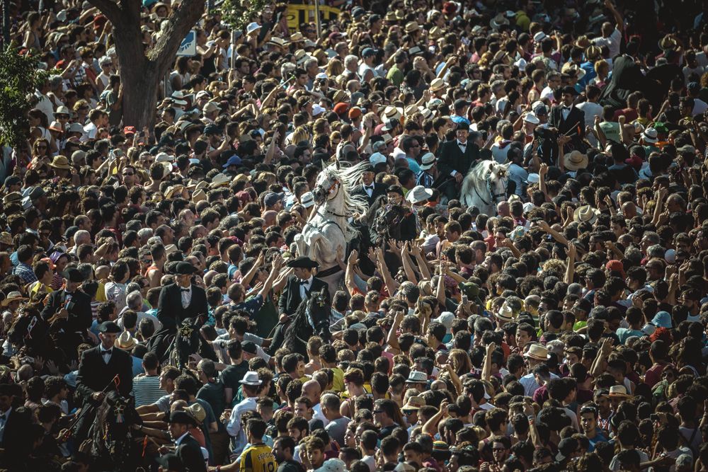 Ciutadella, Spain. 23 June, 2017: A 'caixer' (horse rider) rears up on his horse surrounded by a cheering crowd during the 'Caragol des Born' parade on the eve of the traditional 'Sant Joan' (Saint John) festival in Ciutadella de Menorca