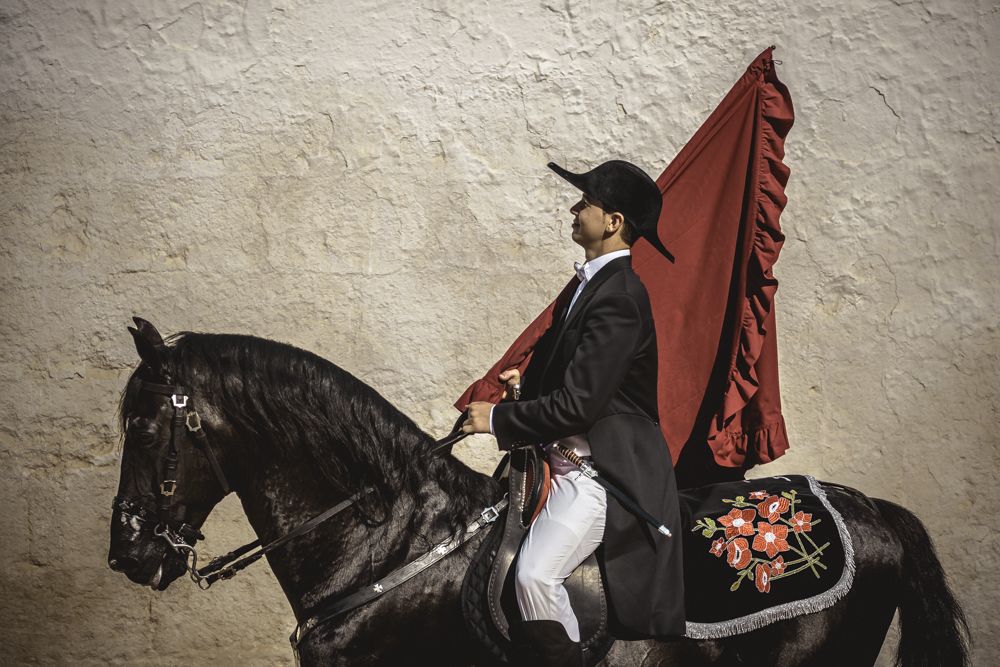 Ciutadella, Spain. 24 June, 2017: A 'caixer' (horse rider) rears up on his horse surrounded by a cheering crowd during the 'Caragol des Born' parade on the eve of the traditional 'Sant Joan' (Saint John) festival in Ciutadella de Menorca