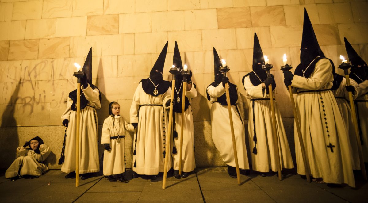Penitents hold torches while they take a short rest during the Good Friday procession of the 'Nuestra Madre de las Angustias' brotherhood in Zamora